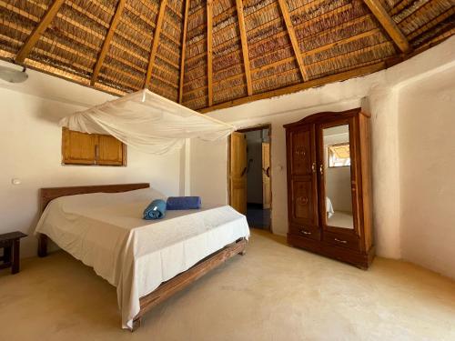 um quarto com uma cama e um tecto de madeira em Chez Peter Pan Anakao em Anakao