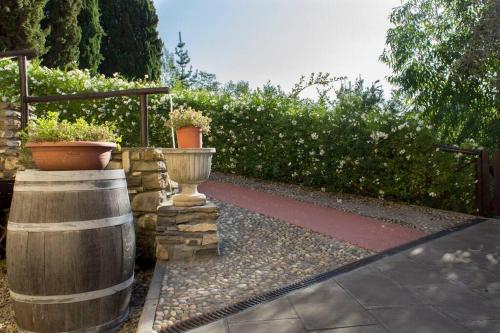 a garden with two wooden barrels and potted plants at Agriturismo a Canonica in Garlenda