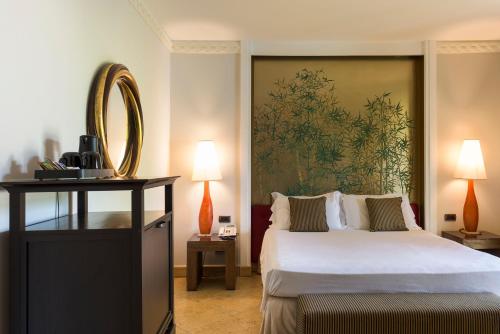 a hotel room with a bed and a mirror at Romano Palace Luxury Hotel in Catania
