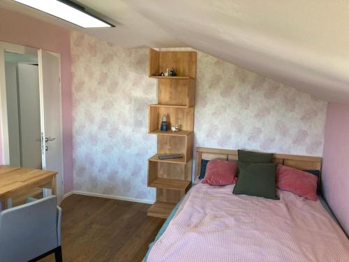 a bedroom with a bed with pink and green pillows at Ferienwohnung Nahe Gmunden in Pinsdorf