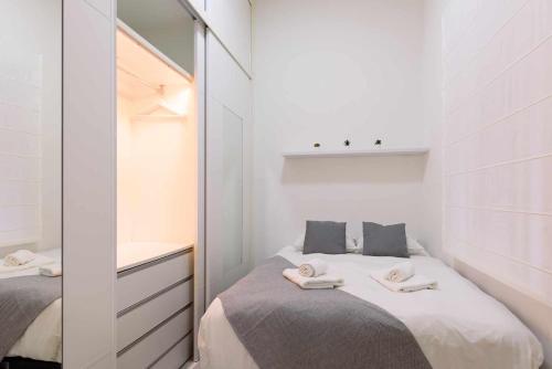 ein kleines Schlafzimmer mit 2 Betten und einem Spiegel in der Unterkunft Apartamento pedro miguel casco antiguo in Sevilla