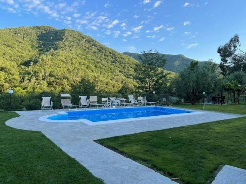 una piscina con sillas y una montaña en el fondo en Agriturismo a Canonica, en Garlenda