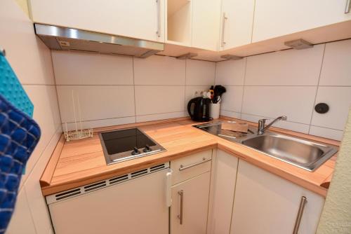 a small kitchen with a sink and a stove at Haus "Jan am Strand" Appartement JAN017 in Döse