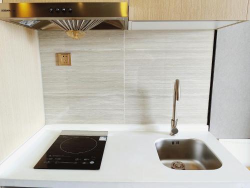 a kitchen with a sink and a counter top at Qingdao Shuiyunjian Apartment in Qingdao