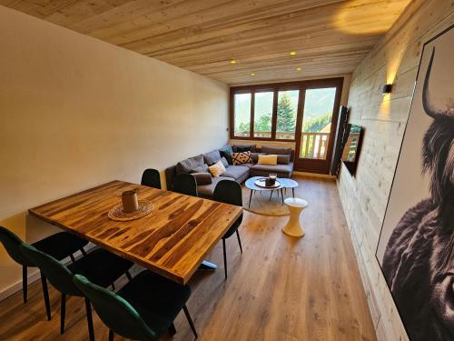 a living room with a table and a couch at Praloup 1600 Appartement T4 rénové in Uvernet-Fours