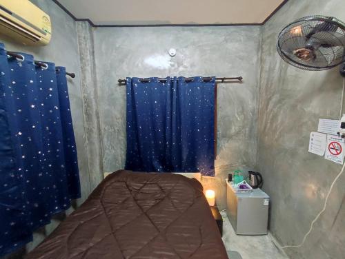 um quarto com uma cama e uma cortina azul em BaanNakanoHomestay em Mae Rim