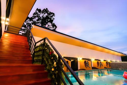 a house with a swimming pool next to a building at Fresh Resort Pattaya in Ban Huai Yai