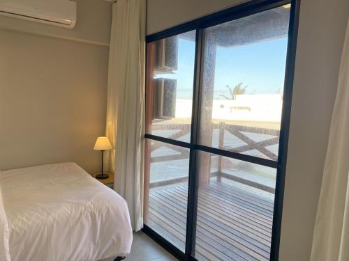 a bedroom with a bed and a sliding glass door at Vila Atlântida Beach in Luis Correia