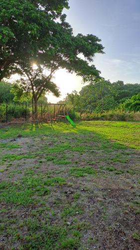 a large field with a tree and a fence at La Kay Catta in Saint-Pierre
