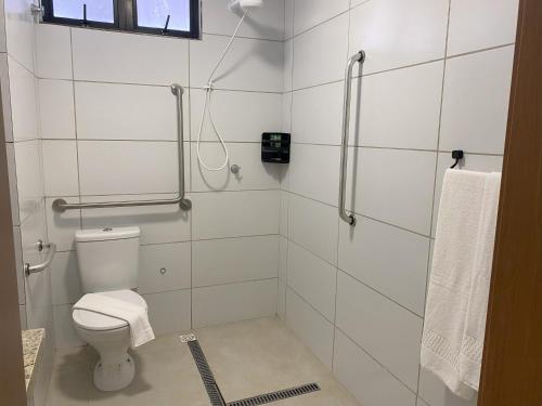 a white bathroom with a toilet and a shower at Vila Atlântida Beach in Luis Correia