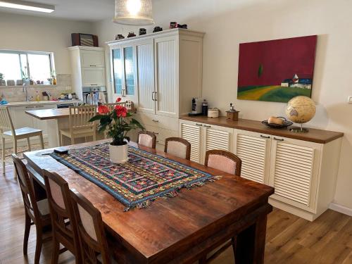 a kitchen with a wooden table and a dining room at In the center of the Moshava in Zikhron Ya‘aqov