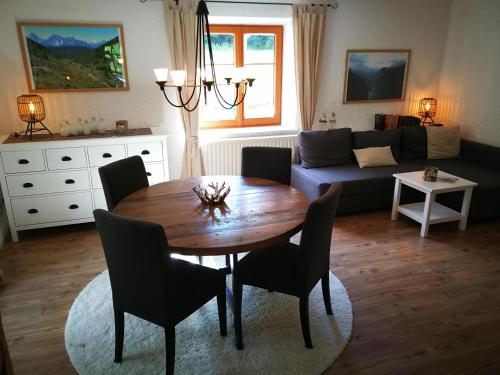 a living room with a wooden table and a couch at Ferienwohnung Achselkopf in Musau