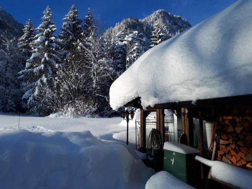 a snow covered building with a snow covered roof at Ferienwohnung Achselkopf in Musau
