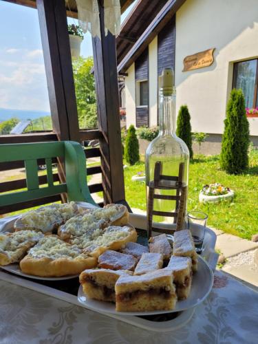 einen Tisch mit einem Teller Brot und einer Flasche Wein in der Unterkunft Casa Dunca in Sighetu Marmaţiei