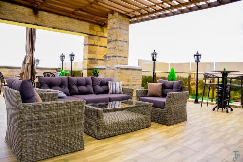 a patio with wicker furniture and a table at TJ's Boutique Hotel in Eldoret