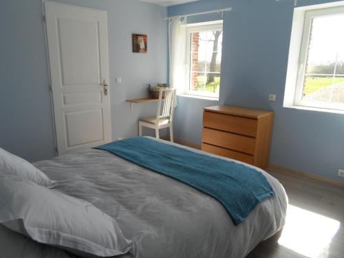 a bedroom with a bed and a dresser and two windows at A L'Oree Du Lin in Mentheville