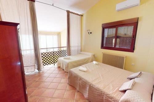 ein Hotelzimmer mit zwei Betten und Balkon in der Unterkunft CASA RURAL CON VISTAS ESPECTACULARES in Doña Rama