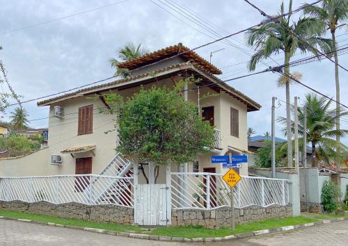 una casa blanca con una valla delante en Pousada Montemar en Ilhabela