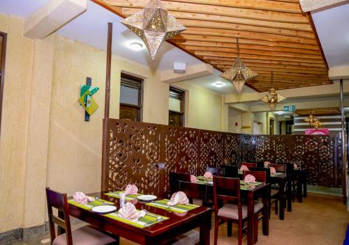 a dining room with tables and chairs in a restaurant at THE GEM HOTEL NAIVASHA in Naivasha