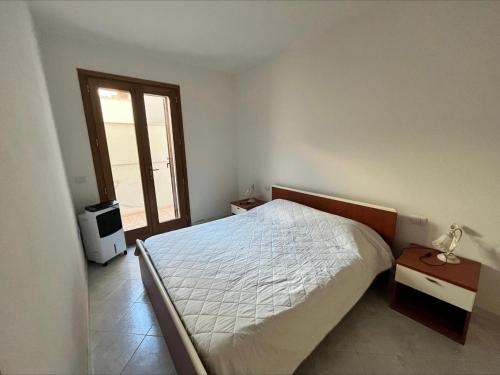 1 dormitorio con cama y ventana en ~ Green House sul Mare ~, en Calasetta