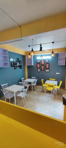 a dining room with tables and yellow chairs at Doris Mountain Cabins Tirthan in Banjār
