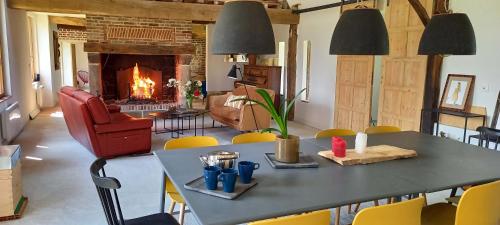 un salon avec une table et une cheminée dans l'établissement La Maison Silleron, à Angiens