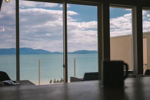 a room with a view of the ocean from a table at LACOSTA in Hōden