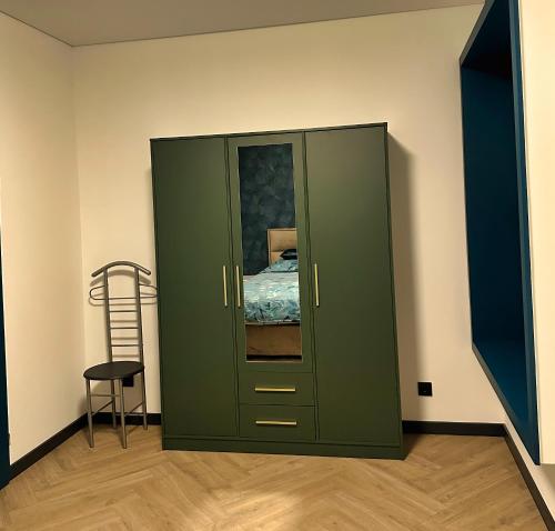 een groene kast in een kamer met een bed bij Luxe appartement dichtbij centrum Drachten in Drachten
