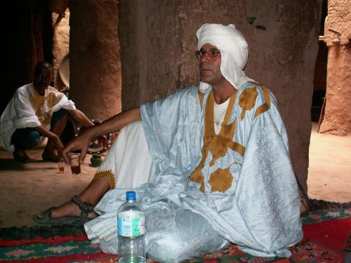 a man is sitting on the floor in a room at Auberge chez hammadi in Zagora