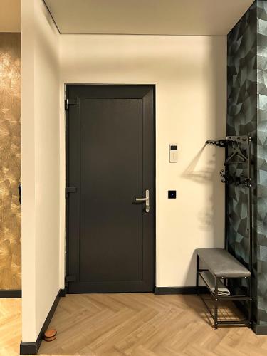 a black door in a room with a chair at Luxe appartement dichtbij centrum B in Drachten