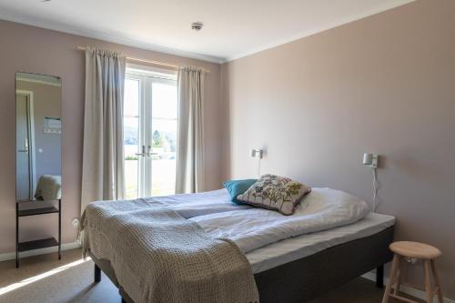 a bedroom with a bed with a window at STF Undersvik Gårdshotell & Vandrarhem in Vallsta
