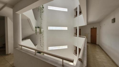 a white staircase in a building with windows at Shangri La in Rosario