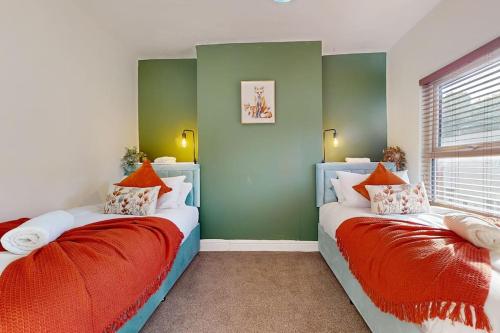 two beds in a room with green and white at Cosy 3 bedroom home from home in Lostock Gralam
