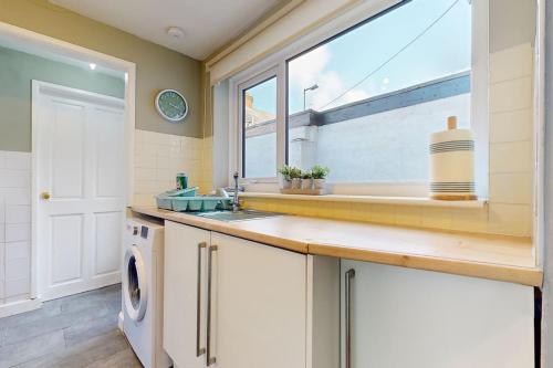 lavadero con lavabo y ventana en Cosy 3 bedroom home from home, en Lostock Gralam