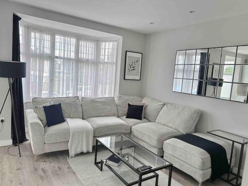 a living room with a couch and a table at Private Luxury One Bedroom Apartment with parking in Palmers Green