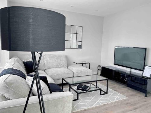 a living room with a couch and a television at Private Luxury One Bedroom Apartment with parking in Palmers Green