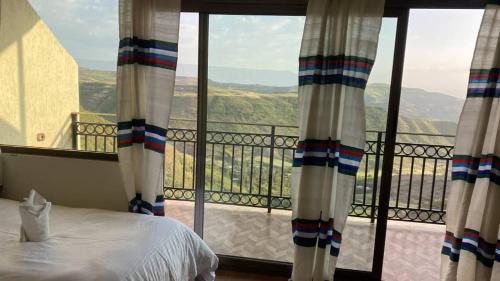 a bedroom with a bed and a large window at Amba Lodge Lalibela in Lalibela