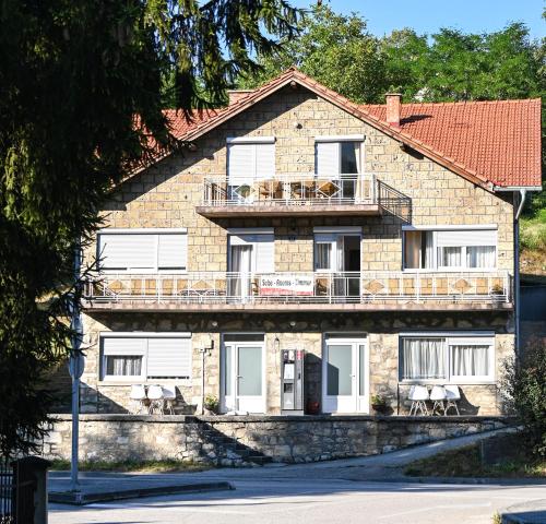 a large brick building with a balcony at Apartmani Jaguzovic in Mrkonjić Grad