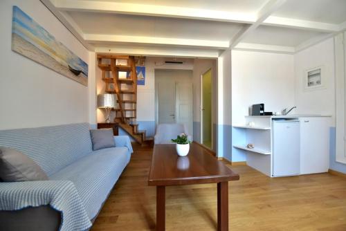 a living room with a blue couch and a table at Douskos Guesthouse in Hydra