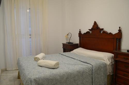 a bedroom with a bed with two towels on it at Las Arenas-Islantilla-Huelva in Islantilla
