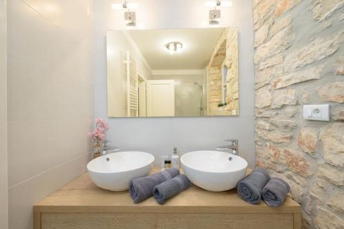 a bathroom with two sinks and a mirror at Villa Onelia by IstriaLux in Vodnjan