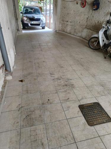 a tile floor with a car parked in a garage at S & K Apartment free indoor parking in Athens