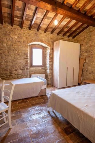 a large room with two beds and a window at Abbazia San Pietro in Valle in Vagli