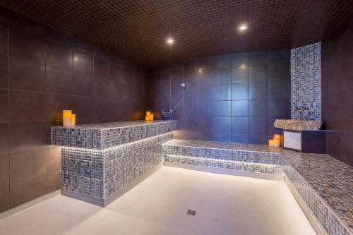 a bathroom with two sinks and a tub with blue tiles at Hotel Lac Brome in Lac-Brome