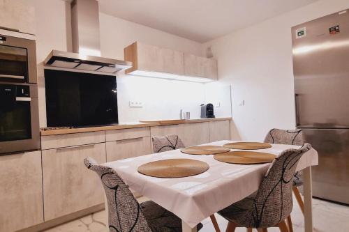 une cuisine avec une table et des chaises dans une cuisine dans l'établissement Spacieux, lumineux, chic ,60m2 au coeur du Lyon 6ème -Quartier Foch- avec grand balcon, à Lyon