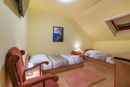 um quarto com 2 camas, uma secretária e uma mesa em Kisduna Étterem-Panzió em Dunaharaszti