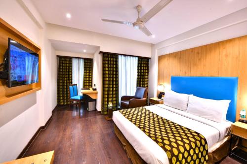 a hotel room with a bed and a desk at The Fern Residency, Subhash Bridge, Ahmedabad in Ahmedabad