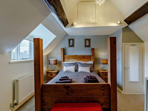 ein Schlafzimmer mit einem großen Holzbett im Dachgeschoss in der Unterkunft Beautiful 2 Bedroom Riverside Cottage in Bridgnorth