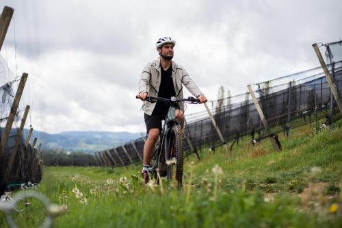 a man riding a bike in a field at Mahorko Wein Wellness Wasserbüffel in Glanz an der Weinstraße 