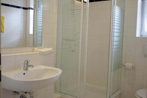 a bathroom with a sink and a glass shower at Motel Hormersdorf in Hormersdorf